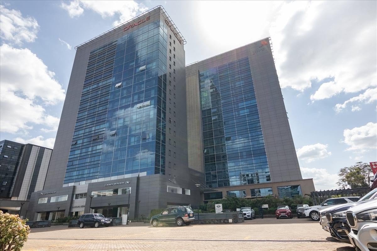 Exterior view of the glass-facade Delta Corner Tower under a bright sky.