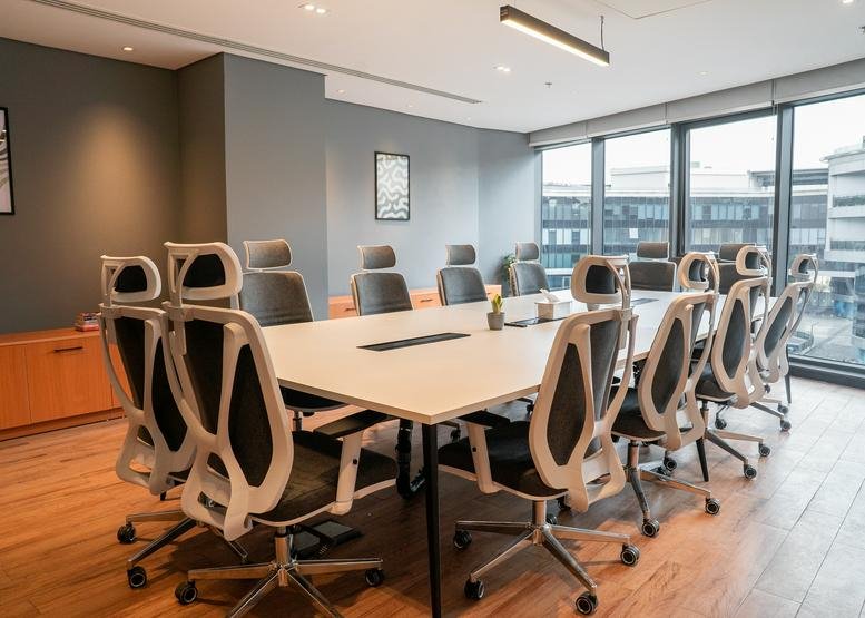 Meeting room at Enawalks Plaza, 3rd Floor featuring white table and modern white-framed ergonomic chairs.