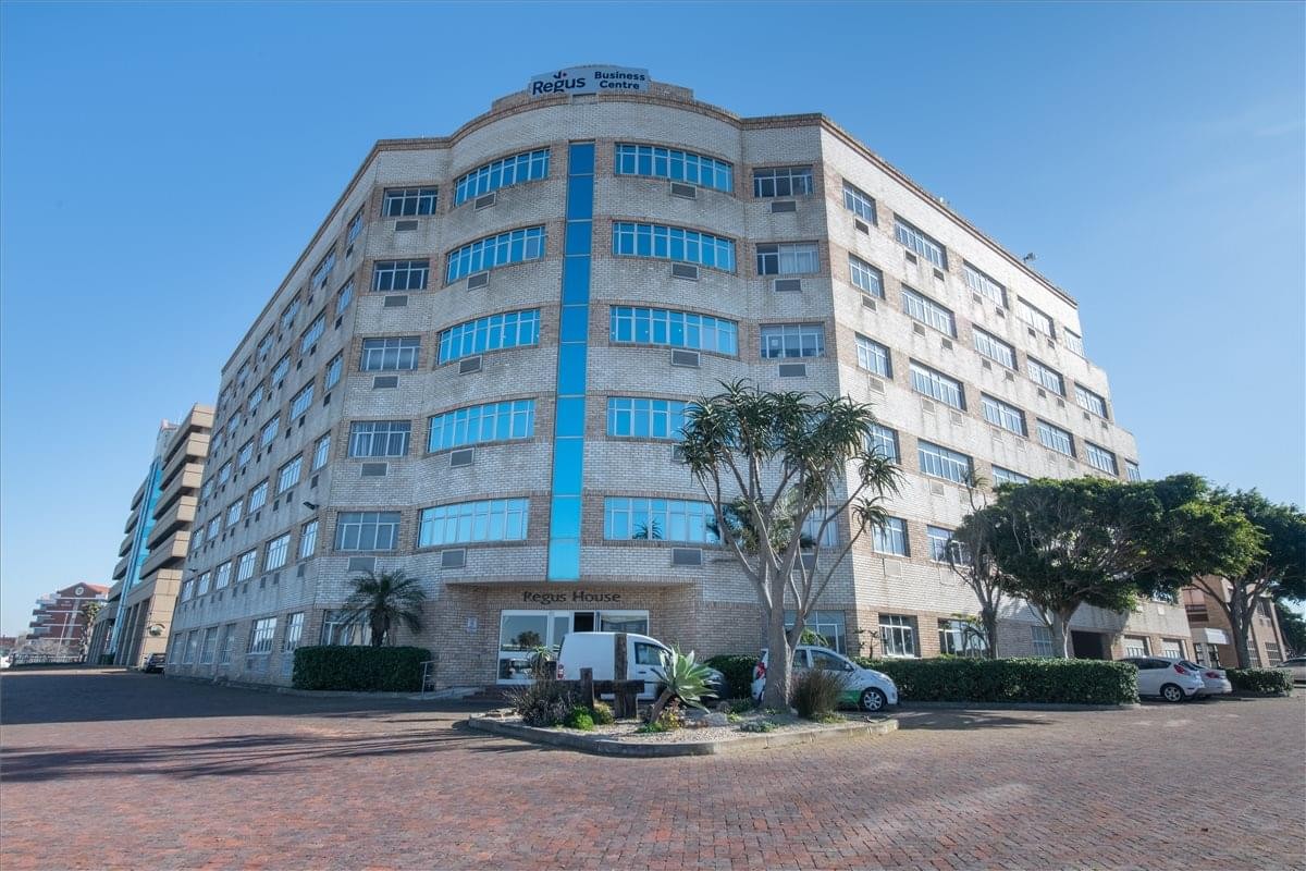 Exterior view of the multi-story First Bowring House with its distinctive curved glass facade.