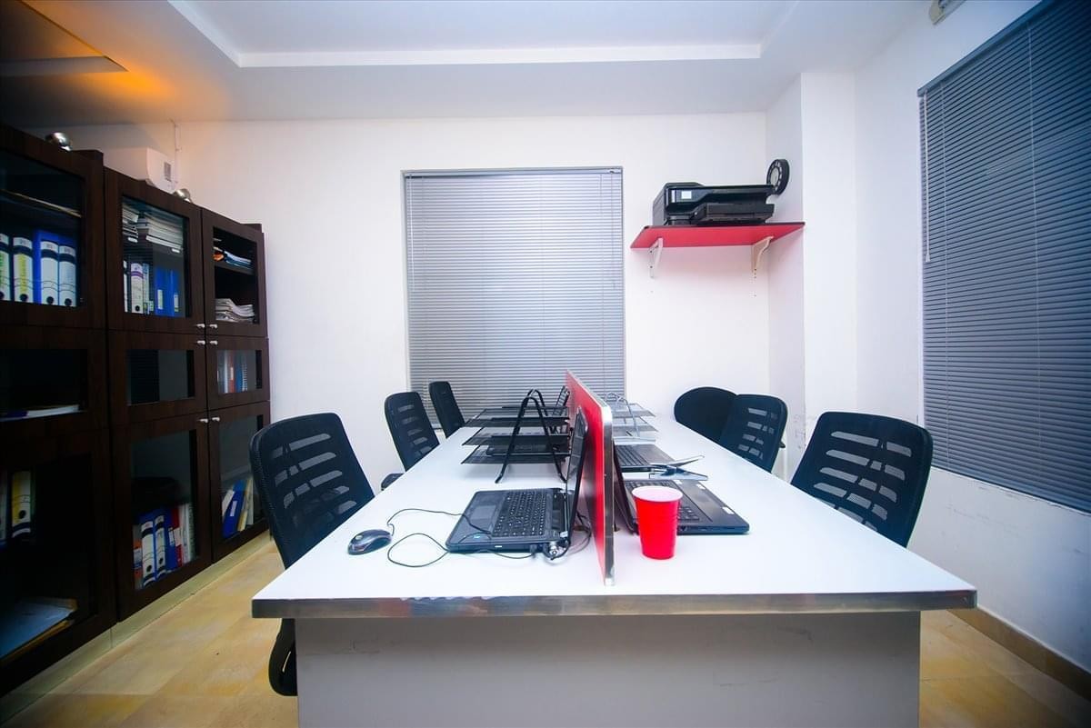 Shared office space with white desks, laptops, and a red cup on Fola Osibo Street Lekki Phase 1.