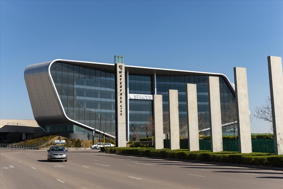Sleek exterior of Gateway West, Waterfall City with its curved metallic facade and glass windows.