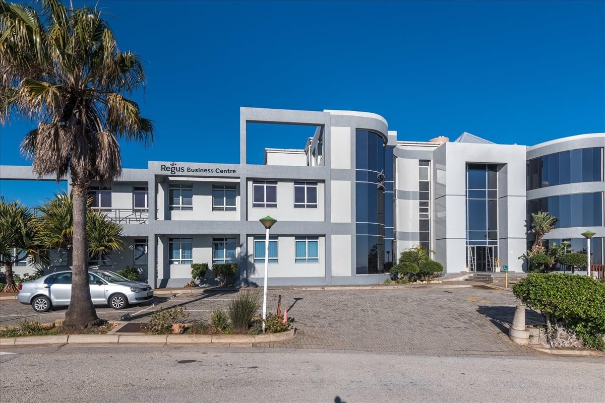 Exterior view of the Harbour View Building featuring a modern white and grey facade and palm trees.