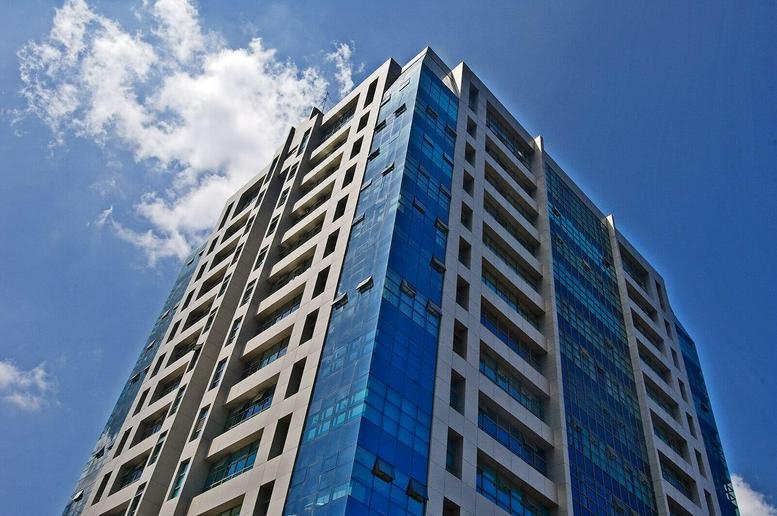 Exterior view of the glass-facade Landmark Plaza against a blue sky.