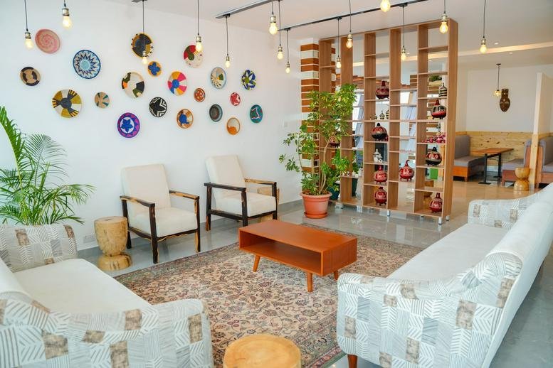 Warm reception lounge at Highway Heights with woven wall art and soft seating.