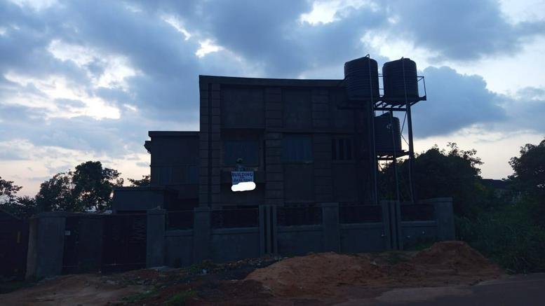 Wide view of the building exterior against a cloudy sky at dusk.