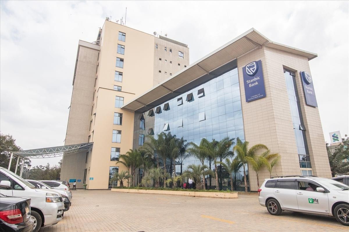 Exterior view of the contemporary Purshottam Place building with its glass facade and palm trees.