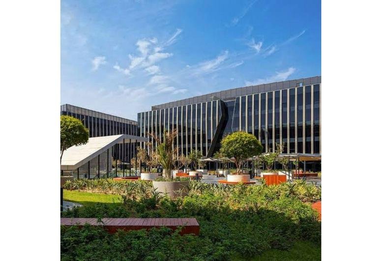Modern multi-story exterior of SODIC EDNC, SODIC Eastown with landscaped gardens and glass facade.