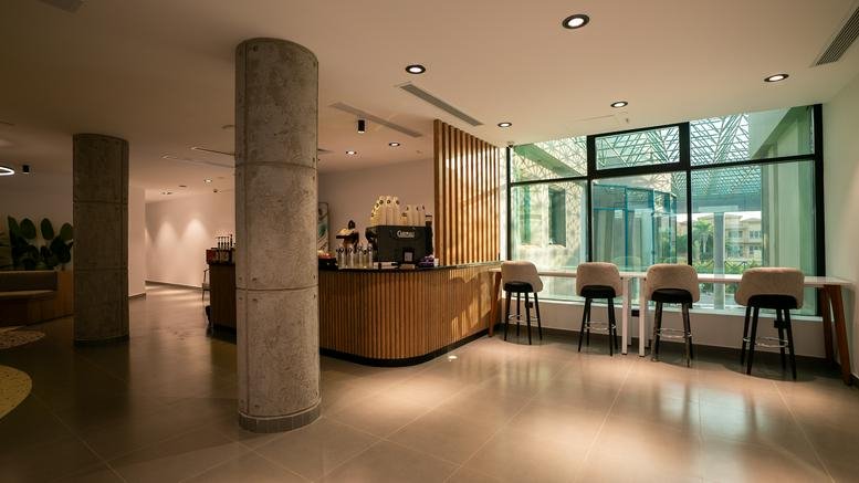Spacious coffee bar with stools and large windows at Al-Rabwa Compound, Street 15, Sheikh Zayed.