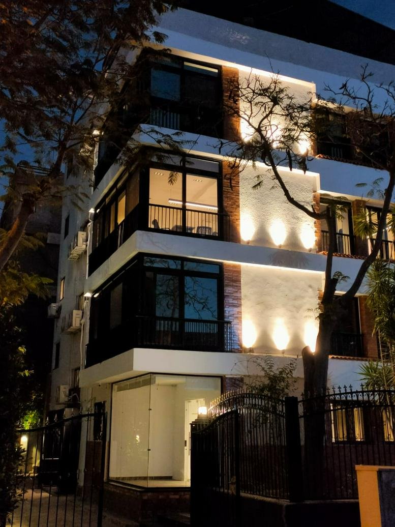 Night view of the building facade illuminated by warm architectural lighting.