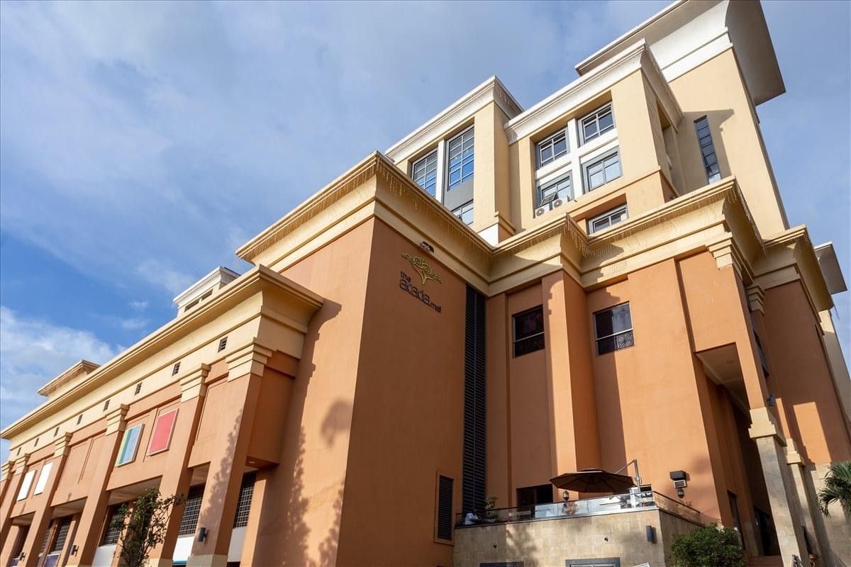 Exterior view of the multi-story tan facade of The Acacia Mall, 14-18 Cooper Road.