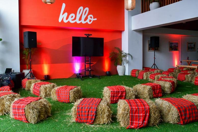 Event space at The Address Building, 7th Floor, Muthangari Drive with hay bale seating on green turf and a red wall.