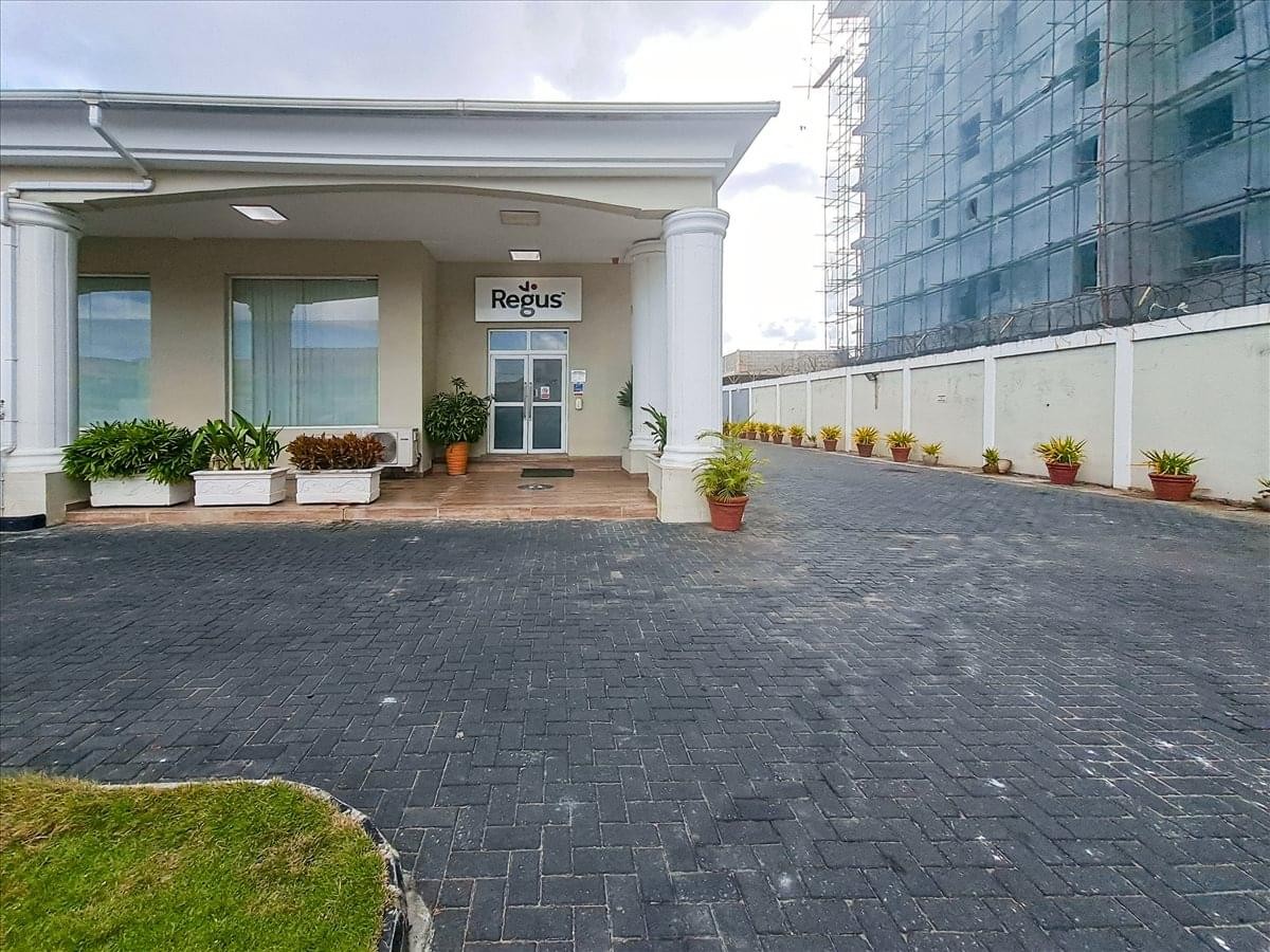 Exterior entrance of The Waterside building with white columns and manicured flower boxes.