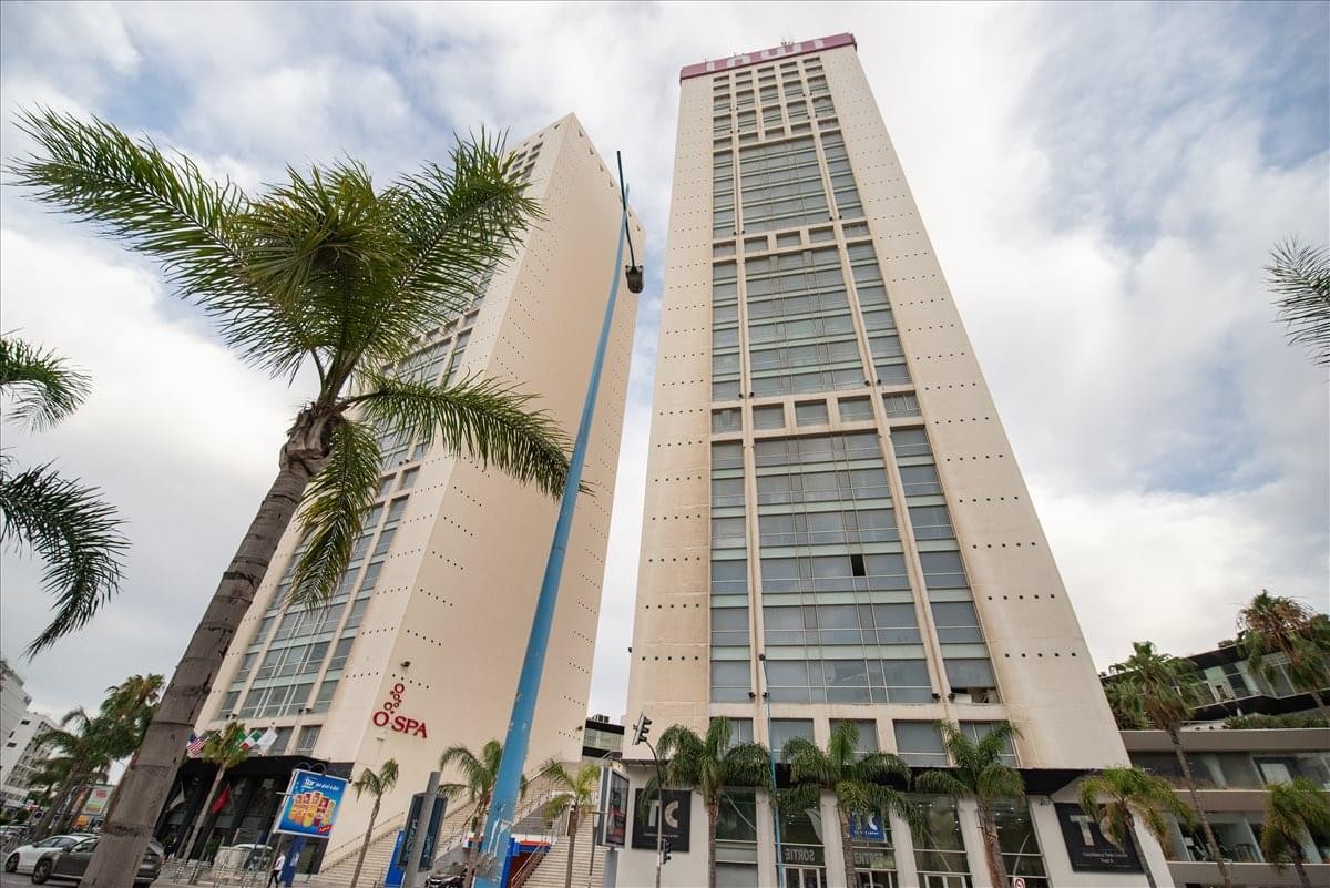 Exterior view of the Twin Tower Centre 2 reaching into a cloudy blue sky in Casablanca.