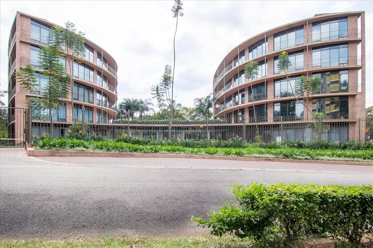 Exterior view of the curved brick facade and lush gardens at Vienna Court, State House Crescent Road.