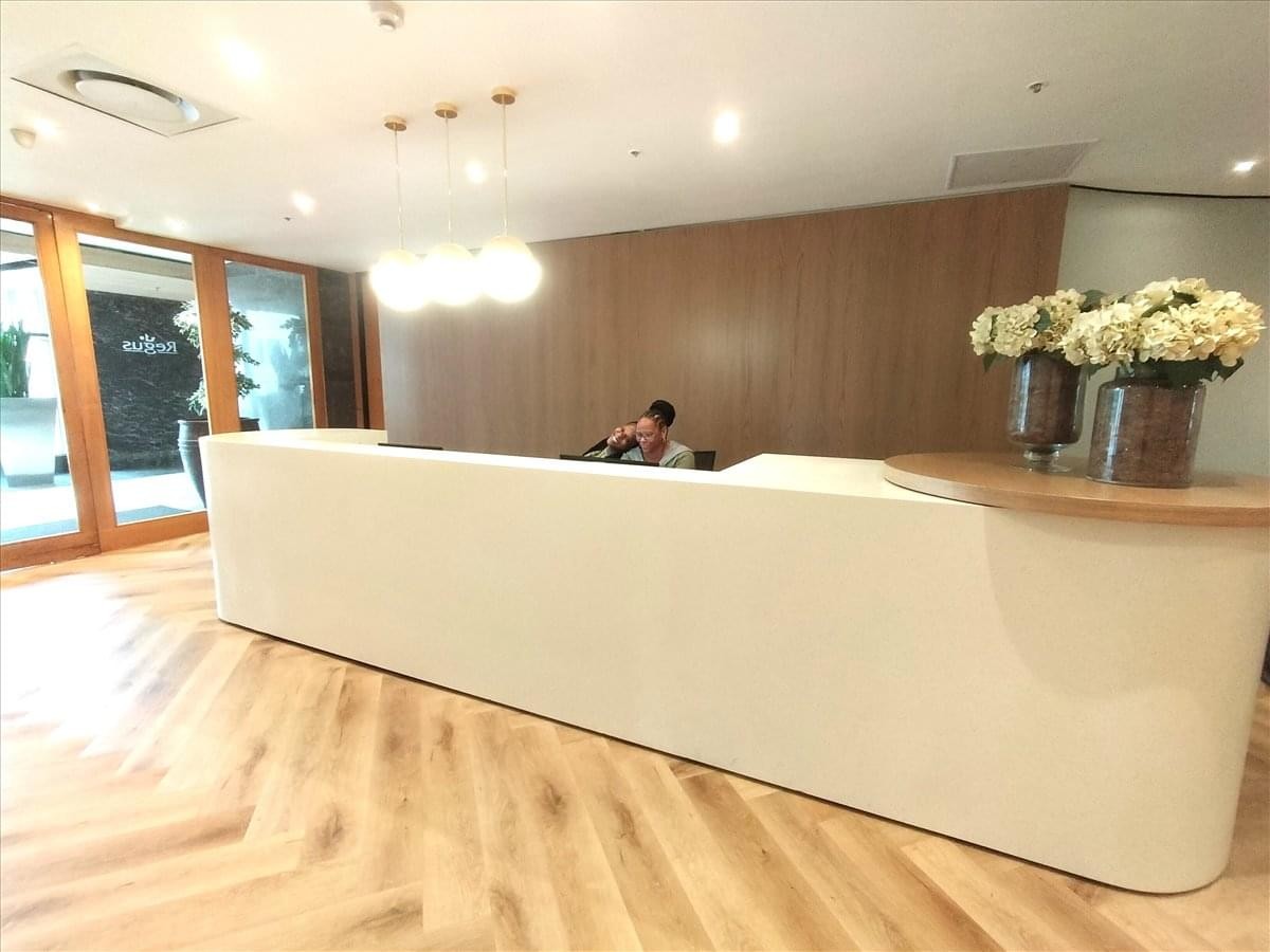 Modern reception desk with wooden herringbone floors at West Tower 2nd Floor, Nelson Mandela Square.