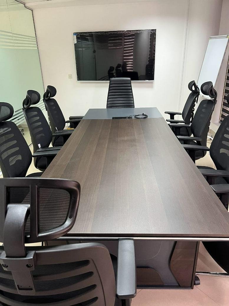 Large boardroom with a dark wood table and black executive chairs at Bank of Industry House.