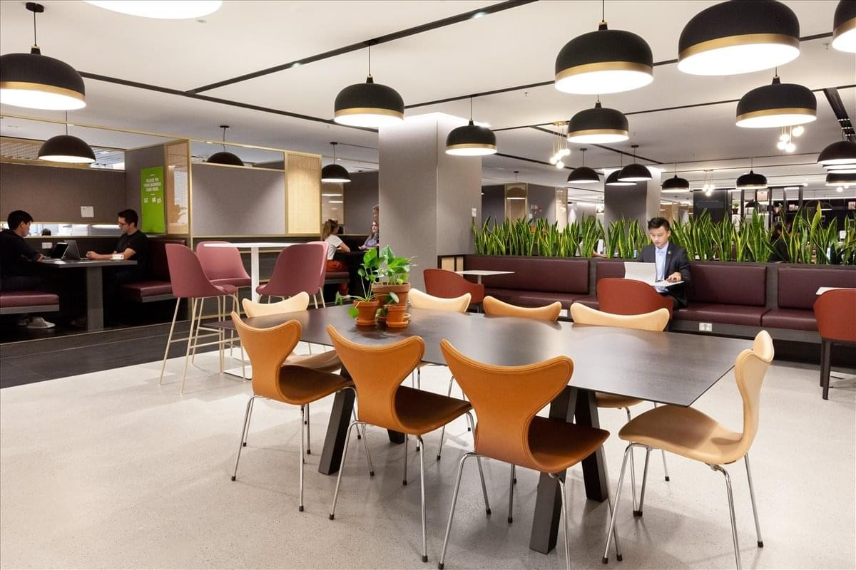 Spacious communal dining area at Global Trade Centre with modern pendant lighting and warm wood accents.
